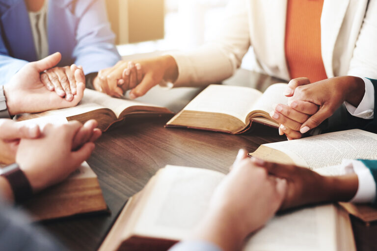 group holding hands in prayer