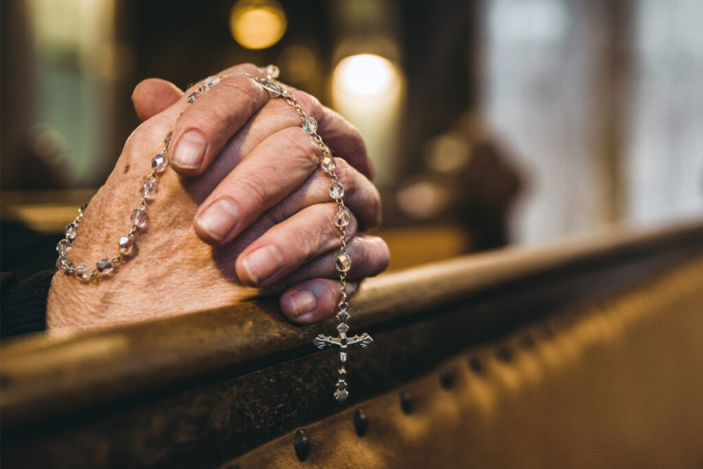 prayer hands with rosary beads