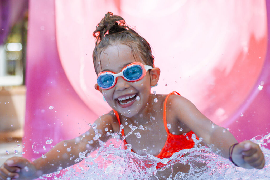 young girl on waterslide wearing goggles